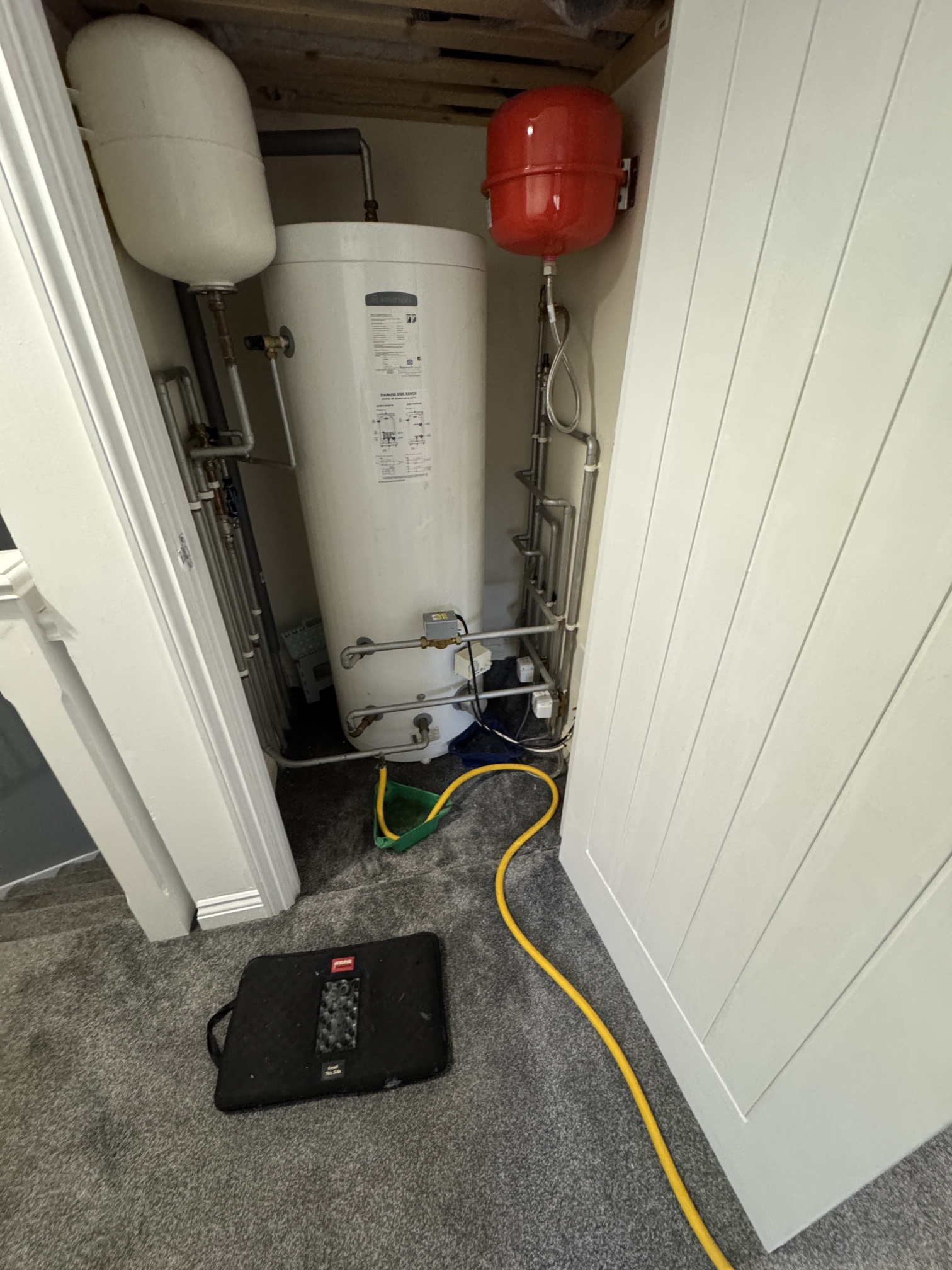 Professional unvented cylinder installation showing drainage equipment and safety setup