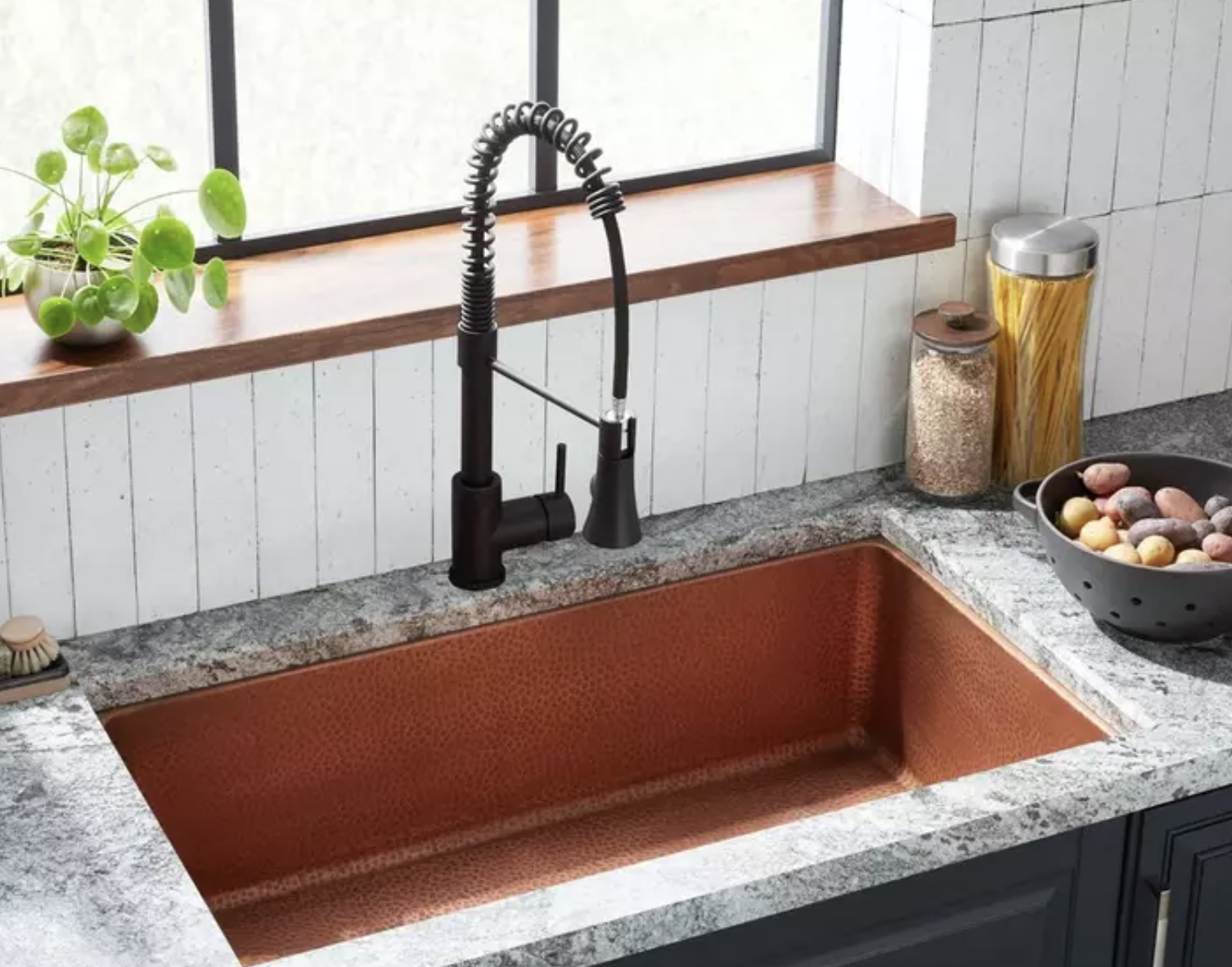Professional undermounted copper kitchen sink with black tap installation by Rosebourne Plumbing